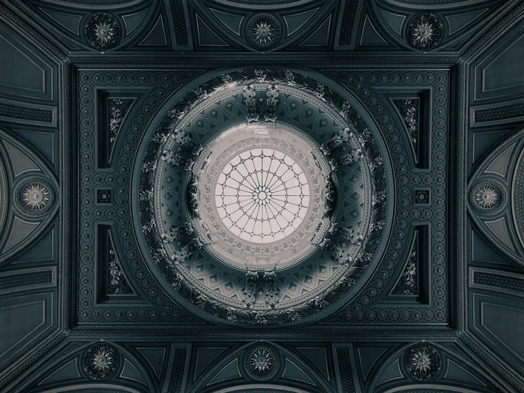 An ornate ceiling with a central glass dome at The Fitzwilliam Museum in Cambridge.